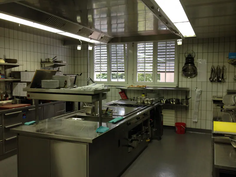 Blick in die Restaurantküche mit Herdblock und Arbeitsflächen aus Chromstahl